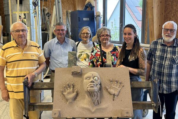 Hochrelief mit dem Titel „Cyborg“, Eifelsandstein, rot / Personen von links nach rechts: Winfried Wolf, Werner Michaelis, Saskia Barthel (Preisträgerin), Inga Förster-Osterheld, Ute Anton, Klaus Daub