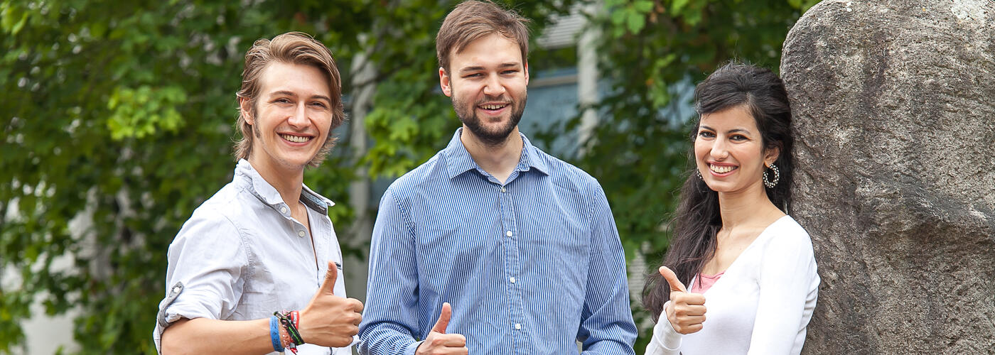 zwei männliche Studenten und eine weibliche Studentin